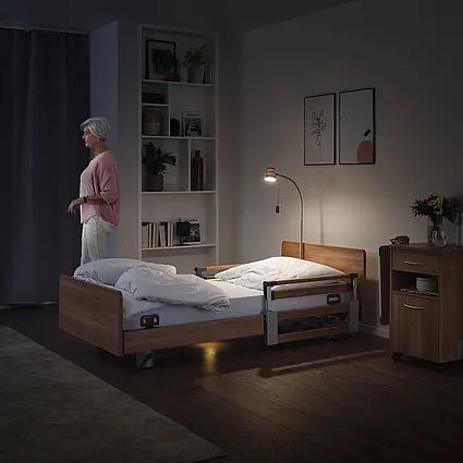 Mieszkanka wstaje w nocy, a system Out-of-Bed przy łóżku do opieki Elvido vervo sygnalizuje ten ruch w dyżurce pielęgniarek