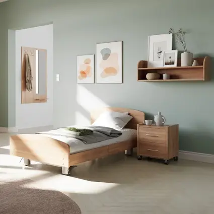 Pflegezimmer mit Holzbett, Nachttisch und Kommode im Tageslichtambiente