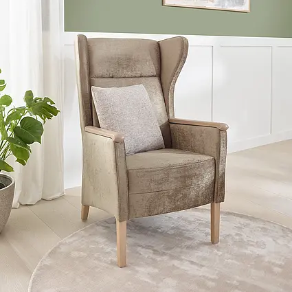 Luna high-back armchair with wooden legs and cushions in a modern care room