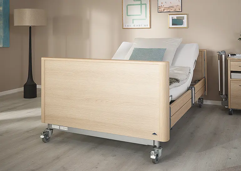 Cama hospitalar de alta resistência Arena com cabeceira e peseira fechadas e encosto ajustável no quarto de cuidados.