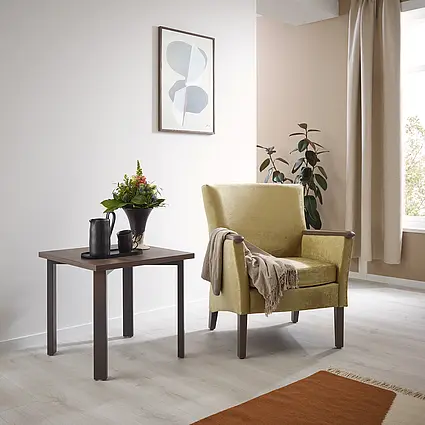 Fauteuil Luna in geel met bijzettafel en bloemdecoratie