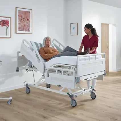 Patiënt in Evario one, verpleegkundige past de werkhoogte ergonomisch aan