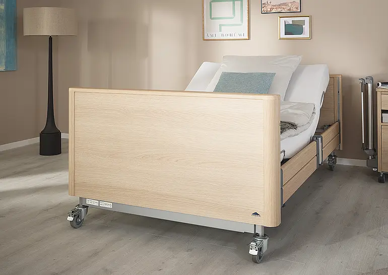 Arena heavy-duty care bed with closed headboard and footboard and adjustable backrest in the care room.