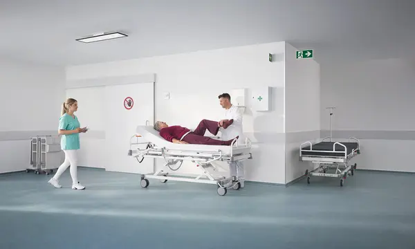 Evario one Krankenhausbett in einer modernen Ambulanz mit medizinischer Ausstattung, entwickelt für sichere und flexible Patientenversorgung.