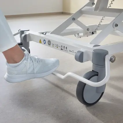 Verzorgende duwt Evario one ziekenhuisbed door de gang van het ziekenhuis