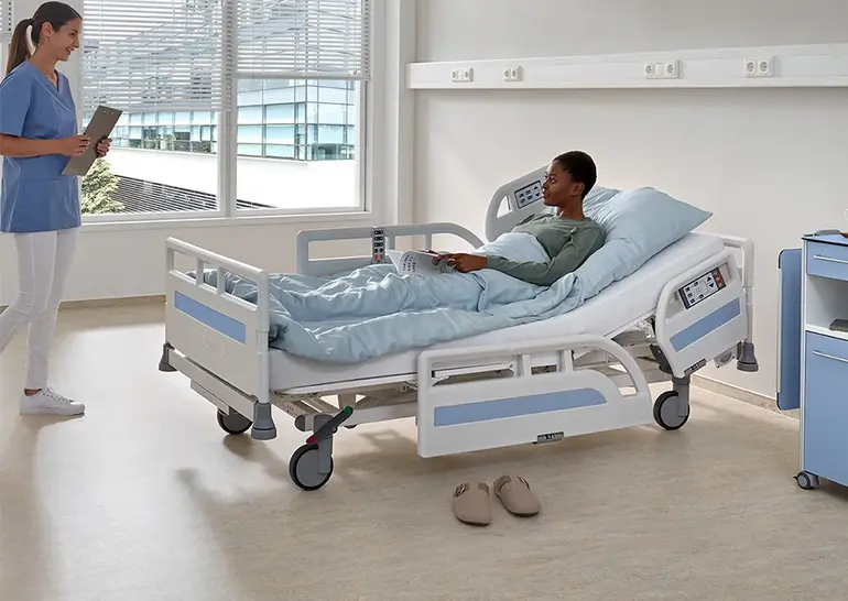 Evario one ziekenhuisbed met gedeelde 3/4-veiligheidszijden voor veilige mobilisatie en comfort van de patiënt.