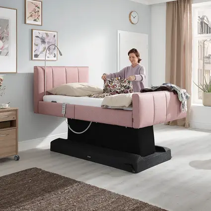 La imagen muestra la cama Libra - variante deluxe con base del colchón elevada, lo que proporciona una altura cómoda para doblar la ropa.