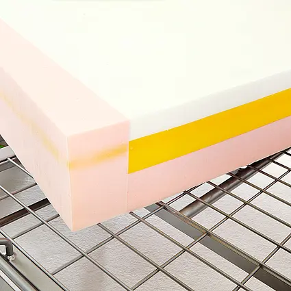 Mattress with multi-layer foam core on metal mattress base for pressure-relieving support.