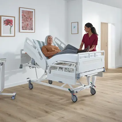 Potilas Evario one -laitteessa, hoitaja säätää työskentelykorkeuden ergonomisesti