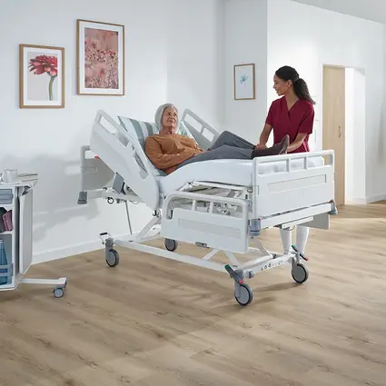 Patient in Evario one, nurse adjusts working height ergonomically