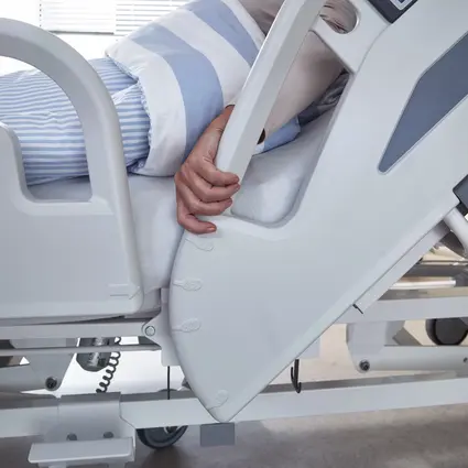 Patient reaches for raised safety sides with angle indicator on the Evario one