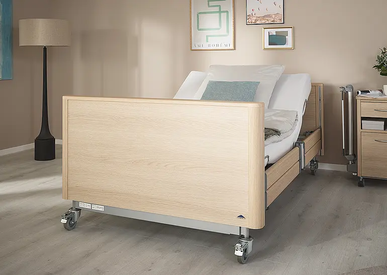 Cama hospitalar de alta resistência Arena com cabeceira e peseira fechadas e encosto ajustável no quarto de cuidados.