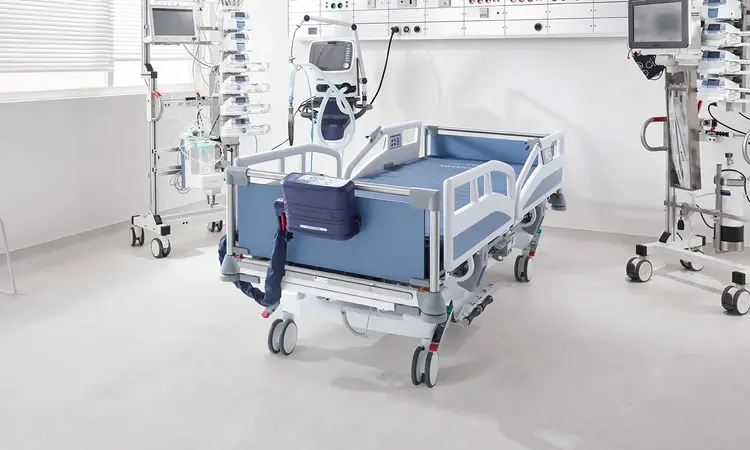 Sistema de presión alternante Smartline Pro de Novacare sobre la cama hospitalaria Sicuro tera Intenvis de Stiegelmeyer en una habitación de hospital