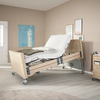 Arena heavy-duty care bed with electrically raised backrest and ergonomic sitting position.