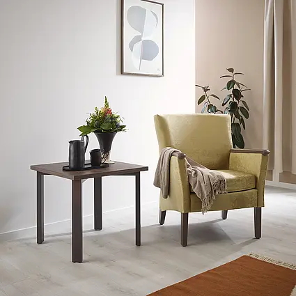 Luna armchair in yellow with side table and floral decoration