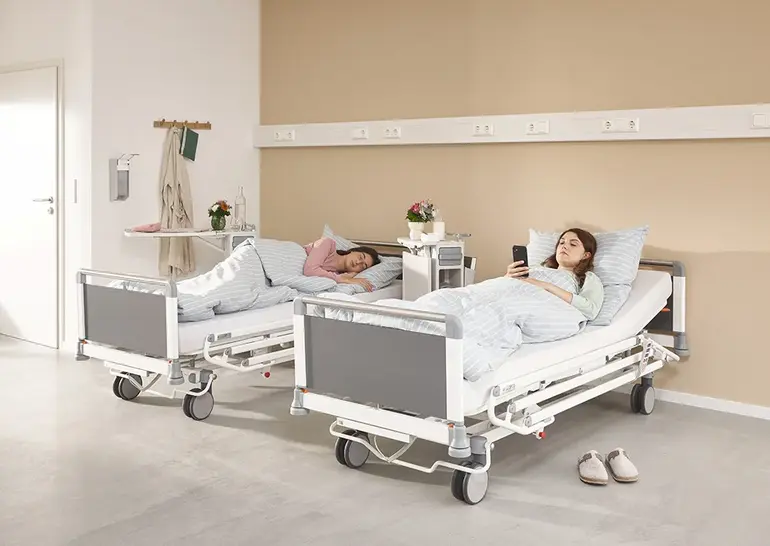 Evario one ziekenhuisbed met draaibare 3/4-veiligheidszijden voor ergonomische bediening en veiligheid van de patiënt.