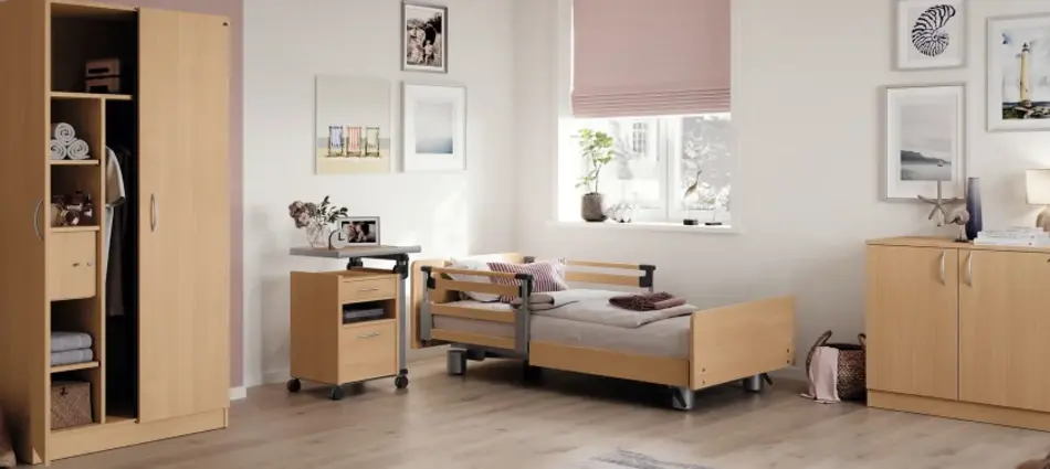 Pflegezimmer mit Pflegebett, Schrank und Kommode in heller Holzoptik