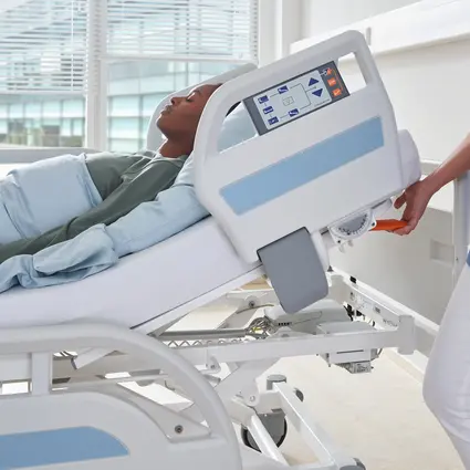 Pielęgniarka obsługuje dźwignię na oparciu pleców, aby ustawić pozycję CPR